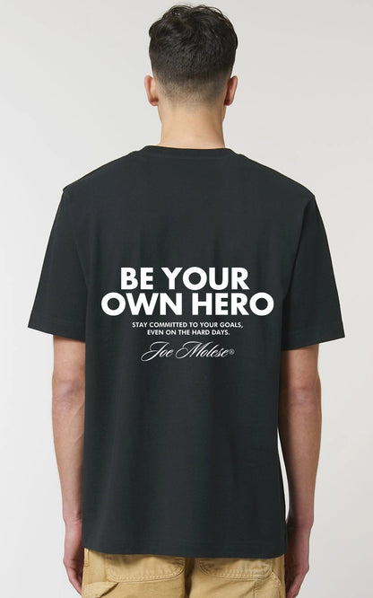 Selbstbewusste Person trägt schwarzes Be your own Hero Streetwear T-Shirt 